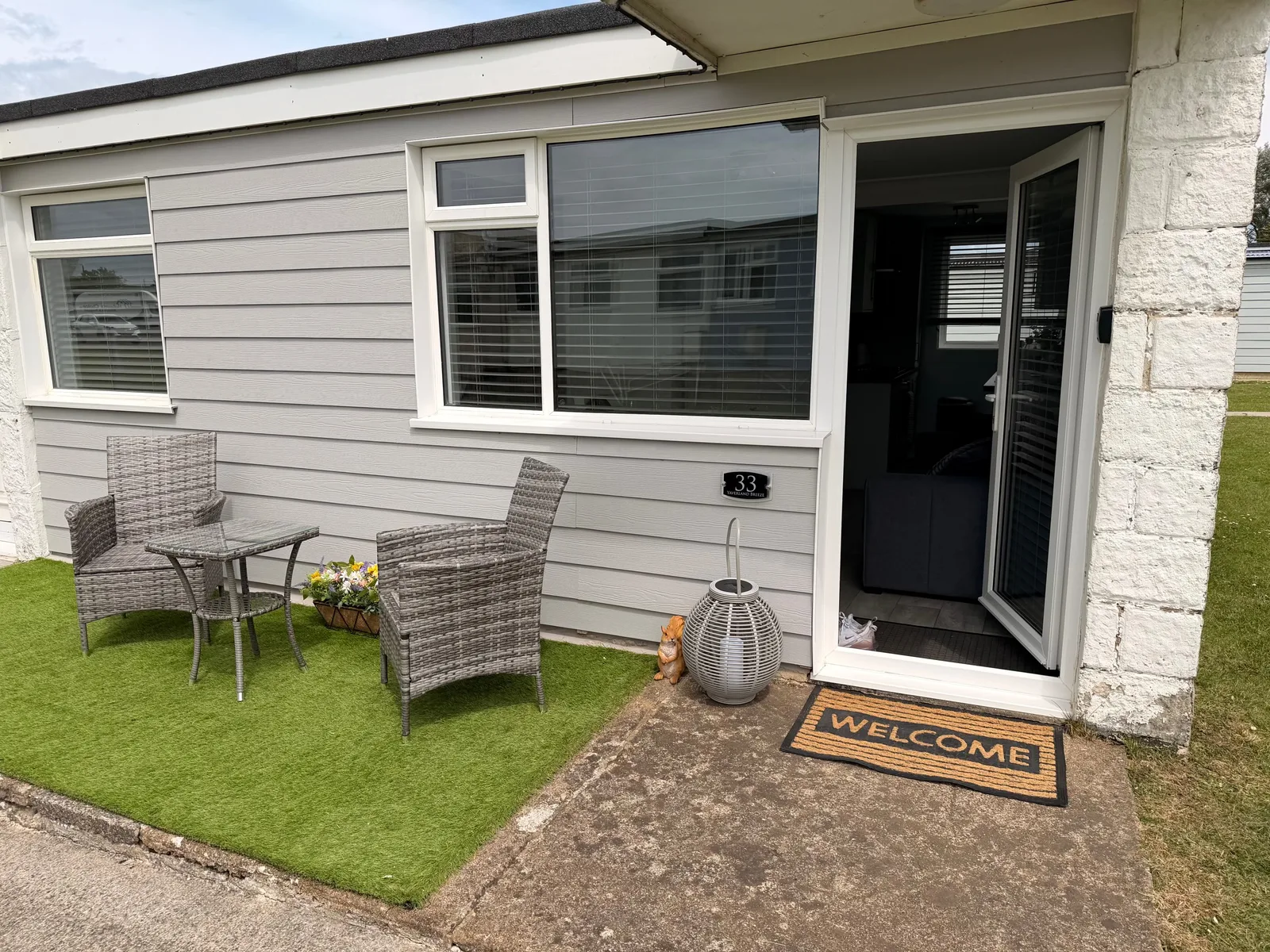 Yaverland Breeze entrance with rattan garden furniture and a welcome mat by the door