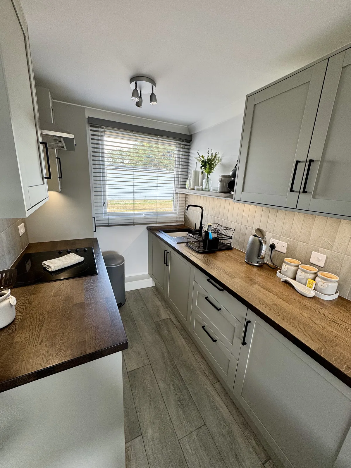 Yaverland Breeze kitchen with sage cabinets, wooden worktops, hob, sink and kettle